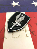 1st Aviation Brigade Metal Emblem pointing left on a american flag