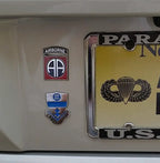 Close-up of military emblems on a vehicle, including an Airborne badge and a parachute badge.