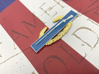 Master Combat Infantryman Badge metal decal on a textured surface with red and white background