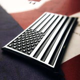 Metallic American flag emblem on a textured surface