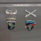 Four military insignias on a reflective surface