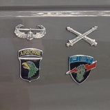 Four military insignias on a reflective surface