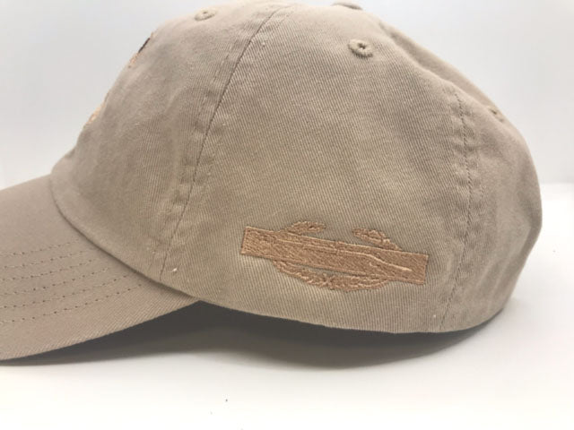 Khaki cap with embroidered combat infantry badge design on a white background