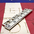 Ft Bragg Edition Metal Auto Decal on a left angle on a red, white and blue background