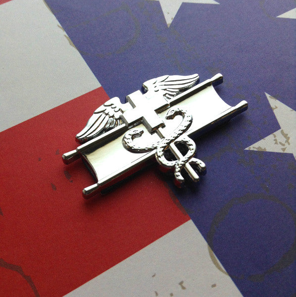 EFMB Metal Car Emblem – Army Medical Badge Chrome Decal Slanted on a Red White and Blue Background