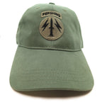 An olive green 56th Artillery Command Pershing Cap featuring a circular embroidered patch with a dagger and lightning bolts, and a rectangular patch above it reading 'PERSHING'.