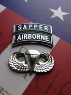 Sapper Tab Chrome Emblem with airborne tab and jump wings badge on an American flag background