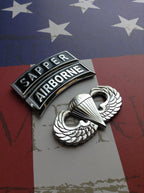 Sapper Tab Chrome Emblem with airborne tab and jump wings badge on an American flag background