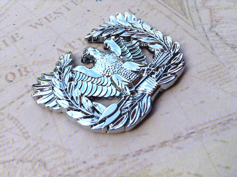 Warrant Officer Eagle Rising Metal Car Emblem on a map background facing left